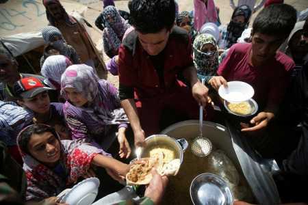 Syrian-Kurdish refugee families queue to get food at the Quru Gusik refugee camp, 20 kilometres east of Arbil, the capital of the autonomous Kurdish region of northern Iraq, on August 29, 2013. Over 1.9 million Syrians in total have fled their homeland, mostly to neighbouring Arab states and Turkey, since the revolt against President Bashar al-Assad erupted in 2011. Photo AFP-Lehtikuva