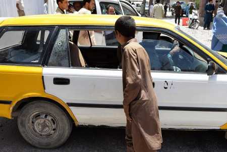 An Afghan youth looks at the taxi in which two foreign women were gunned down by men on a motorcycle, in Herat on July 24, 2014. Two foreign female aid workers were shot dead by unknown gunmen while travelling in a taxi in the western Afghan city of Herat, officials said. Photo AFP-Lehtikuva.