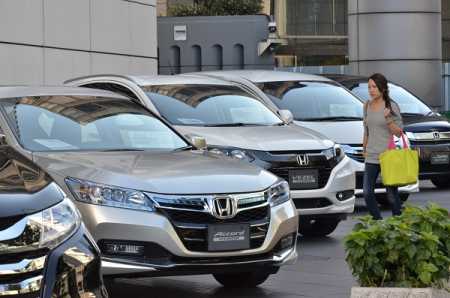 A woman passes before Japanese auto giant Honda Motor's vehicles at the company's showroom in Tokyo on October 28, 2014. Honda said its six-month net profit jumped almost 19 percent, but the Japanese automaker cut its earnings outlook for the full fiscal year. The Civic and Accord maker posted a 288.41 billion yen (2.67 billion USD) net profit in the six months through September, up from 242.87 billion a year earlier, while sales rose to 6.0 trillion yen from 5.72 trillion yen. Photo AFP-Lehtikuva.