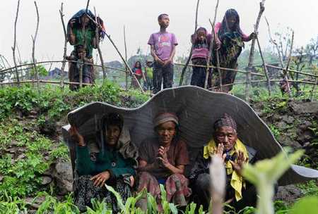 Nepalese villagers shelter from rain during relief operations following an earthquake at Lapu in Gorkha on April 28, 2015. Rescuers in Nepal battled April 28, 2015 to reach remote communities devastated by a huge earthquake that has killed at least 4,349 people, as the impoverished country's leader said relief workers had still not reached many of the worst-hit areas. Photo – AFP / Lehtikuva.