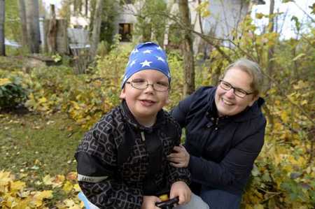 Monica Björkell-Ruhl and his 7-year-old son Michael in their yard in Helsinki on 23 October 2015. Photo – Lehtikuva.